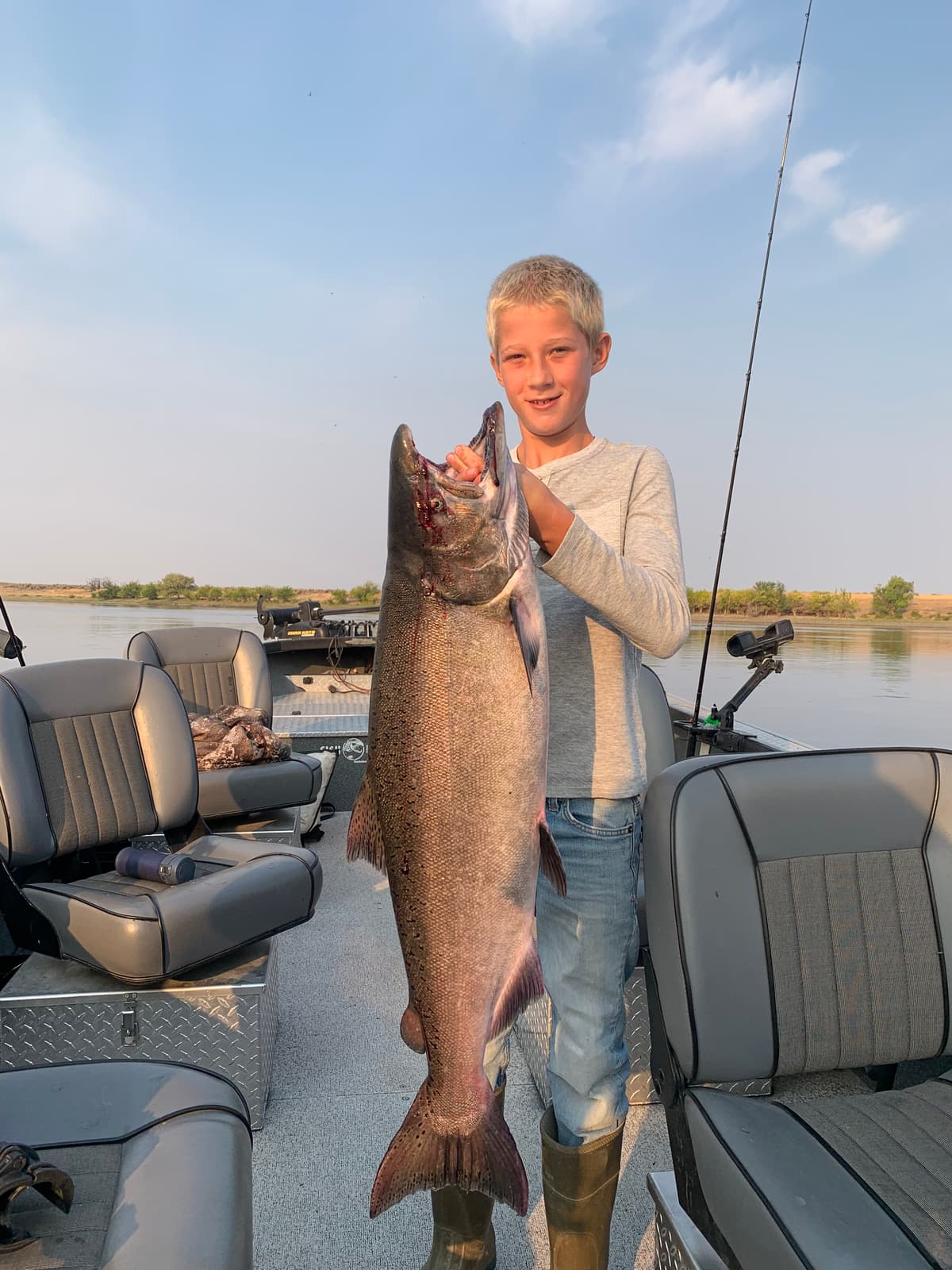 Angler holding trophy king salmon on guided Columbia River boat in Washington