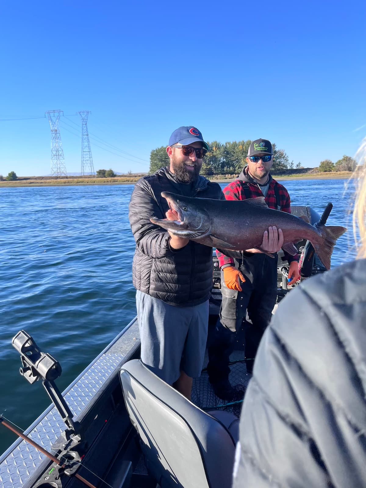 Happy angler holding large chinook salmon on guided Columbia River boat trip