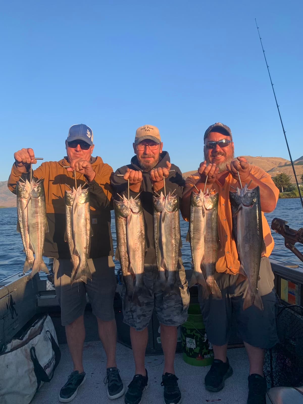 Three anglers showing large salmon haul on guided Columbia River boat trip